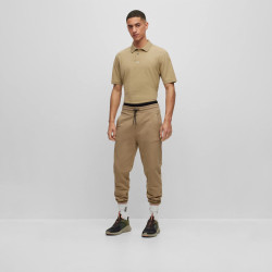 BAS DE SURVÊTEMENT MARRON RESSERRÉ AU BAS DES JAMBES EN MOLLETON ORNÉ D’UN BADGE LOGO DOAK_C HUGO