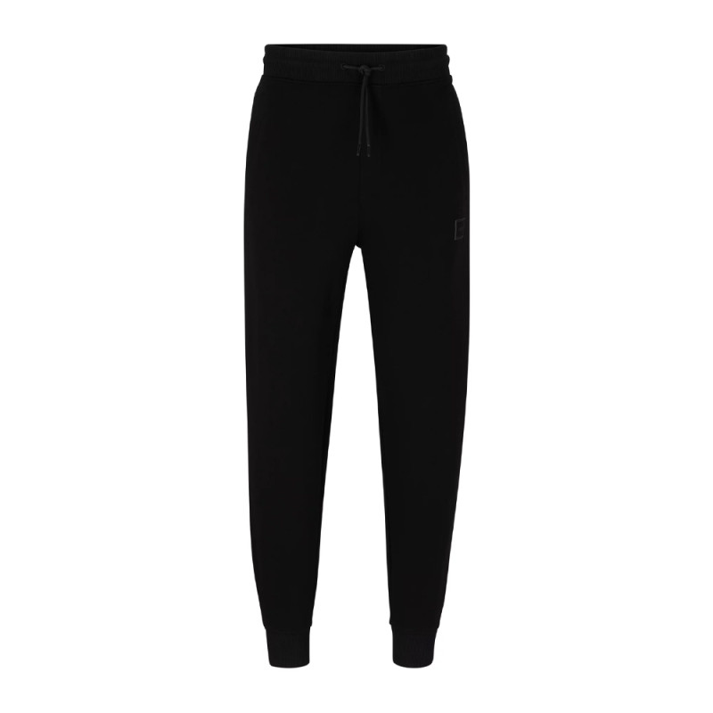 BAS DE SURVÊTEMENT NOIR RESSERRÉ AU BAS DES JAMBES EN MOLLETON ORNÉ D’UN BADGE LOGO DOAK_C HUGO